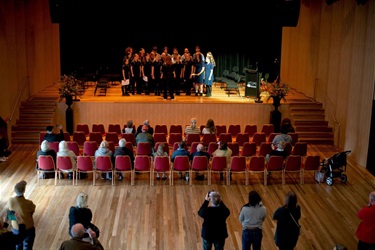 Choir performs on the stage of BMH with audience onlookers