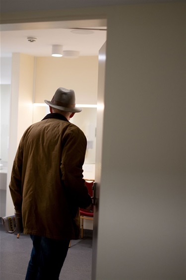 Back of a man in a hat entering the back stage facilities at BMH