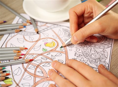 Close up image of hands colouring in