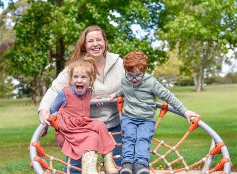 Image of mother and 2 children playing in a park